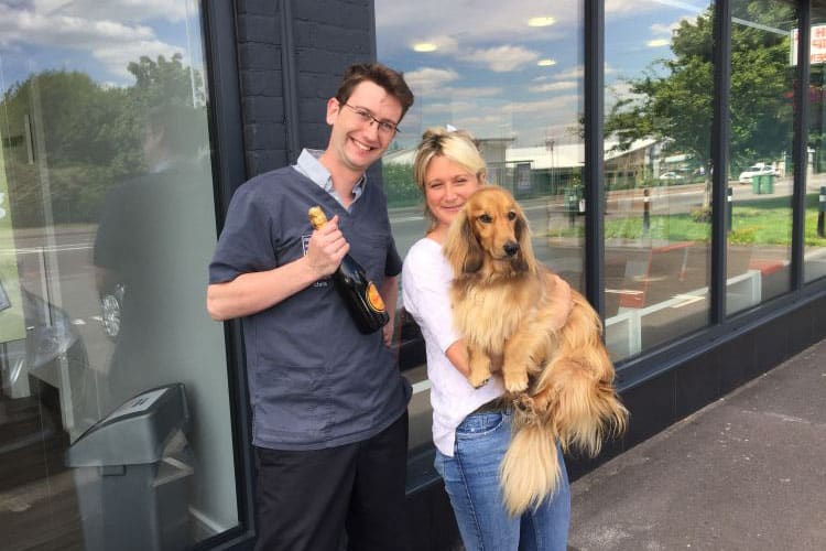 man and woman holding dog